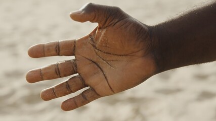 Sand in the hands of men. Close up view of sand running through a man's hands. Sand falling from hand. High quality photo