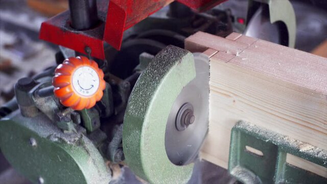 A tenon saw is used to cut the wooden plank in carpenter workshop. Close view