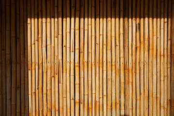 The old brown tone bamboo plank fence texture with  shadow background.