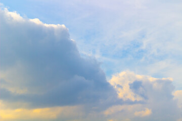 Blue sky in autumn with the sun shining on fluffy clouds.