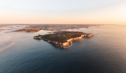 Obraz premium XXL panoramic sunrise aerial drone view of North Head, a headland in Manly and part of Sydney Harbour National Park in Sydney, New South Wales, Australia. Manly and Northern Beaches in background.