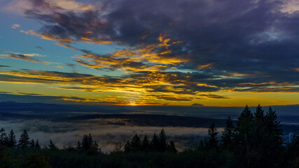 Fototapeta na wymiar Dramatic sunrise over mist-covered Fraser Valley, BC - Autumn