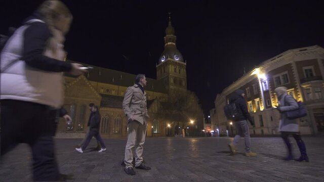 Cinemagraph HD. Congealed world, only one man is moving, standing in old night town Riga, Latvia
