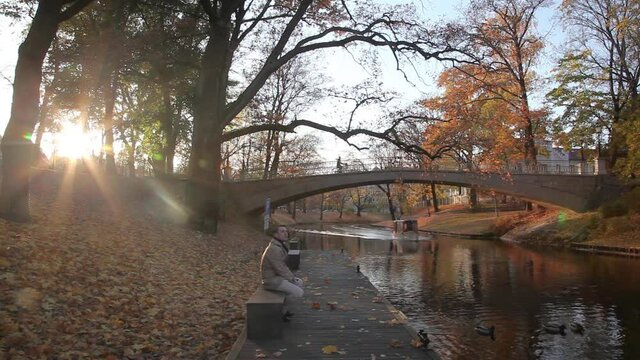  Cinemagraph HD. Congealed world: only man is moving.  City, park , autumn. Riga., Latvia