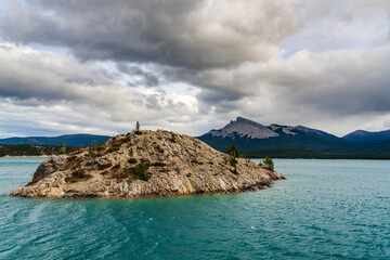 Abraham lake scenery view in summer season. A small rock islet in the foreground and Kista Peak in...