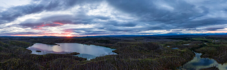 Fototapeta na wymiar Panoramic View of Scenic Lake surrounded my Mountains and Forest at Sunrise in Canadian Nature. Aerial Drone Shot. Northern British Columbia, Canada.