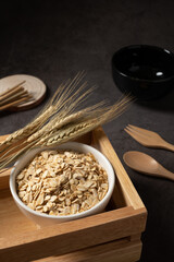 Oat flakes in black bowl top view. Concept healthy eating, dieting and vegetarian food.