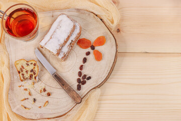 
Christmas cupcake on the table.

Christmas cupcake with tea, knife and dried fruit in the shape of a flower on the board on the left with a place for text on the right on the table, top view close-up