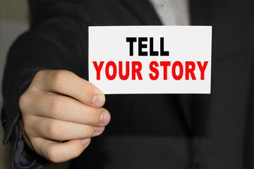 Card with text TELL YOUR STORY on hand. You can use in business, marketing and other concepts.