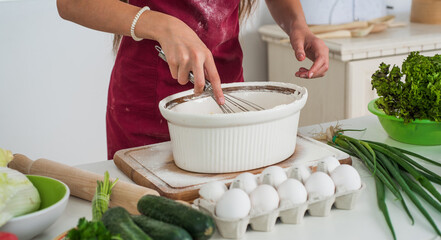 girl beating egg and flour for making dough with beater, professional skills