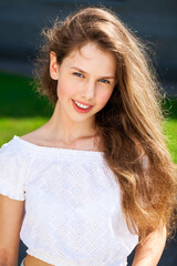 Close up portrait of a young beautiful girl in summer park