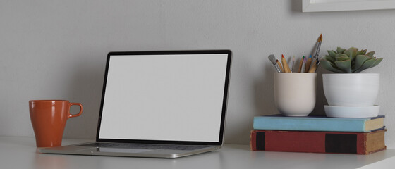 Workspace with mock up blank screen laptop computer with office supplies, clipping path