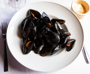 Image of delicious grilled mussels on plate, served with ali-oli sauce