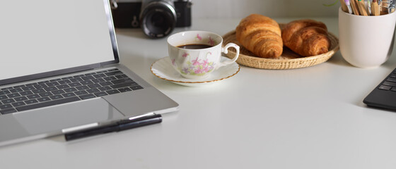 Workspace with laptop, croissant, coffee and copy space, clipping path