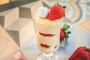 Bowl with white chocolate cream with strawberry and powdered milk brigadeiro