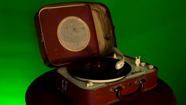 Retro music disc rotates on gramophone and stops with green screen, old sound equipment