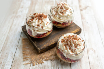 White Chocolate mousse dessert in a glass with raspberry and chocolate shavings  