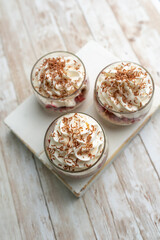 White Chocolate mousse dessert in a glass with raspberry and chocolate shavings  