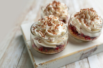White Chocolate mousse dessert in a glass with raspberry and chocolate shavings  