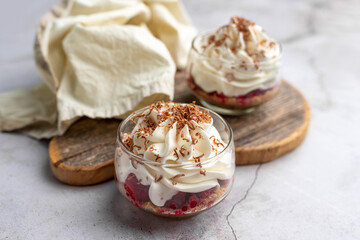 White Chocolate mousse dessert in a glass with raspberry and chocolate shavings  