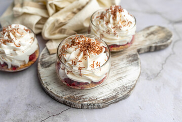 White Chocolate mousse dessert in a glass with raspberry and chocolate shavings  