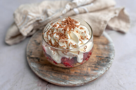 White Chocolate mousse dessert in a glass with raspberry and chocolate shavings  