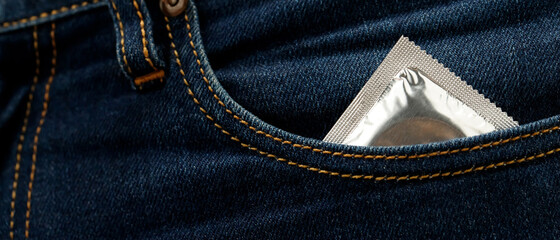 Condom ready to use in pocket Jeans pants, give safe sex concept on the bed Prevent infection and...