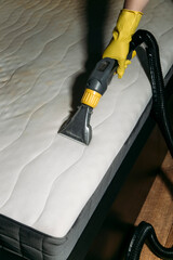 cleaning the mattress with a vacuum cleaner