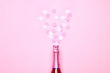 Bottle of champagne and confetti on color background. New Year celebration