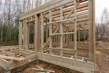 Construction of a frame house in the forest. Autumn