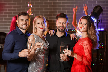 Young people drinking tasty champagne at party in nightclub