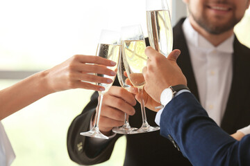 Young people drinking tasty champagne at party in office