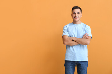 Fototapeta na wymiar Handsome young man in t-shirt on orange background