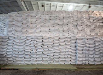 bags of sugar in the warehouse. A wall of sugar sacks in a large warehouse.