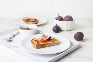 Plate with tasty sandwich with fig jam on table