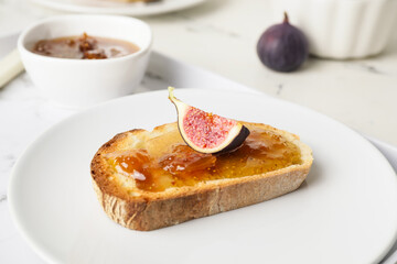Plate with tasty sandwich with fig jam on table, closeup
