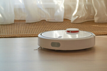 The robot vacuum cleaner automatically cleans the floor in the apartment and cleans the carpet