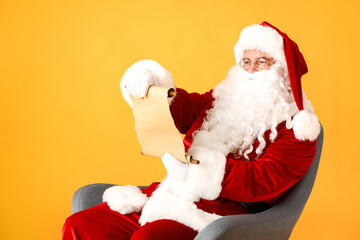 Santa Claus reading letter on color background