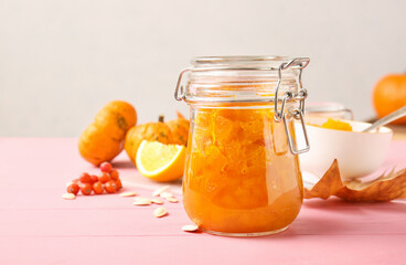 Jar of tasty pumpkin jam on table