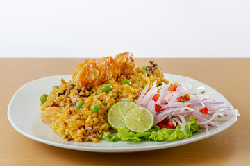Peruvian food, seafood rice with onion, and lemon.