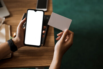 Close up woman holding mobile phone with a white screen and credit card. Online shopping concept