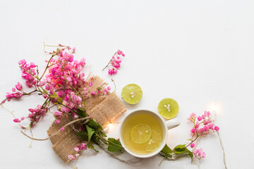 Obraz na płótnie Canvas herbal healthy drinks honey ,lemon for sore throat with pink flower arrangement flat lay postcard style on background white 