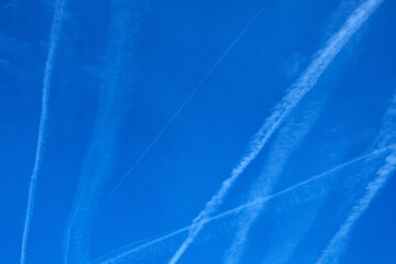 many traces of flying planes in the blue sky