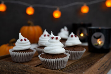 Halloween ghost cupcakes , homemade sweet chocolate muffins with meringue ghost
