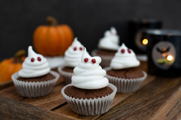 Halloween ghost cupcakes , homemade sweet chocolate muffins with meringue ghost