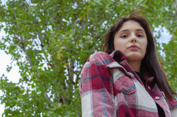 Portrait of an adult long-haired woman in plaid shirt with loose hair.