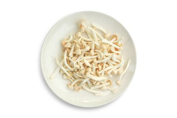 Pile of piece white Shimeji Mushrooms or beech mushroom in circle plate isolated on white background.