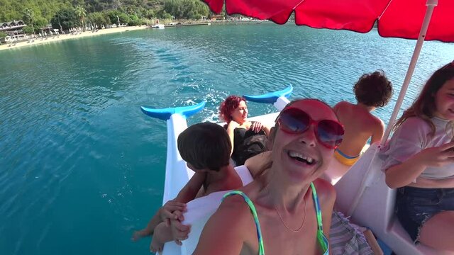 Oludeniz beach, Fethiye, Turkey - 24th of October 2020: 4K Women and children having fun on the water bicycle at the Blue lagoon, selfie
