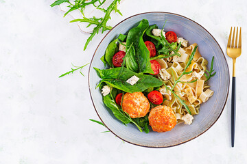 Italian pasta. Pasta  with meatballs,  cheese and fresh salad on light background. Dinner. Top view, overhead. Slow food concept