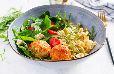 Italian pasta. Pasta  with meatballs,  cheese and fresh salad on light background. Dinner.  Slow food concept
